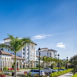 a row of buildings and trees with a blue sky