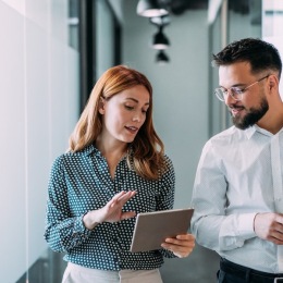 a man and a woman looking at a tablet